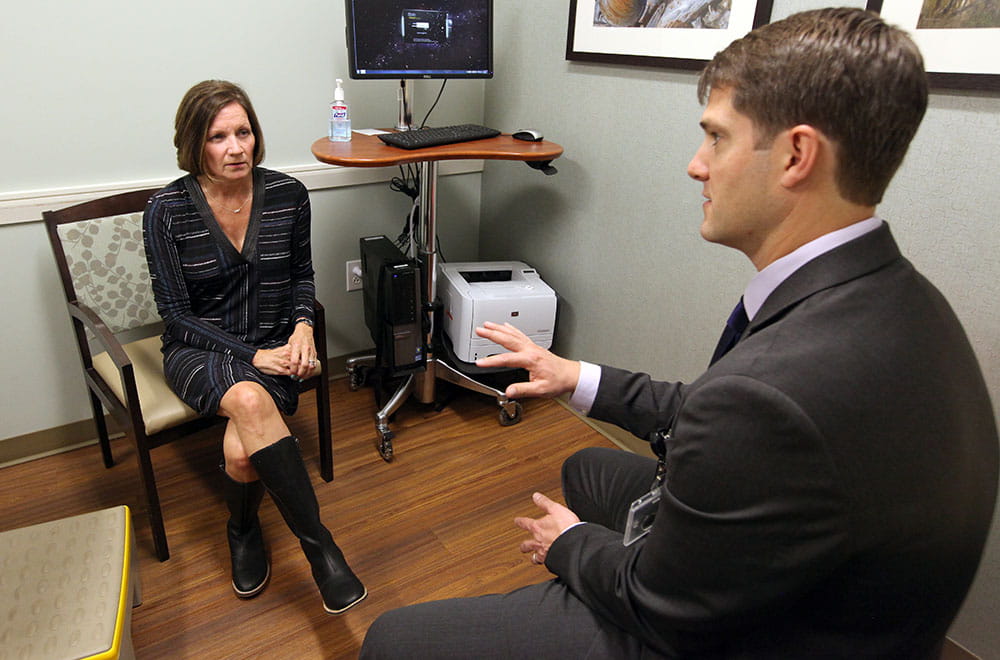 Breast cancer survivor Shari Frontz talks with plastic surgeon Jason Ulm.