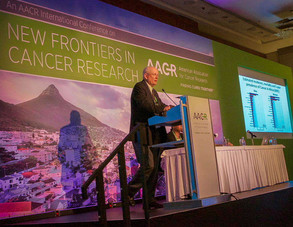 Raymond DuBois speaks on stage at a cancer conference