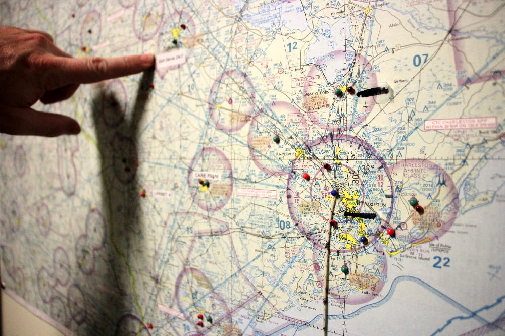 A pilot points to a location on a map inside the MEDUCARE flight control office.