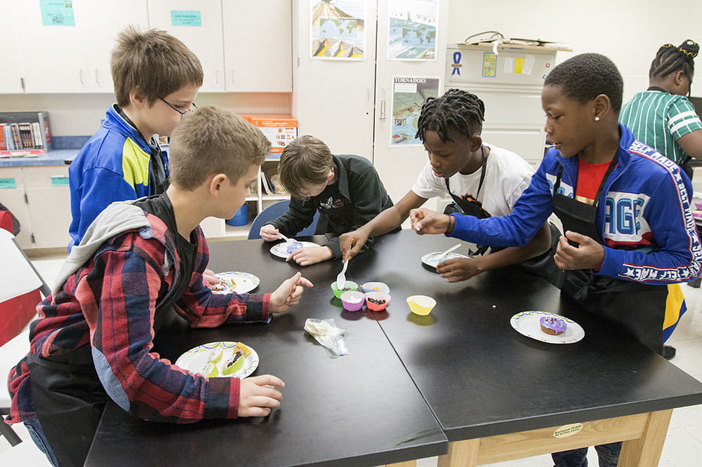 Boys decorate muffins.