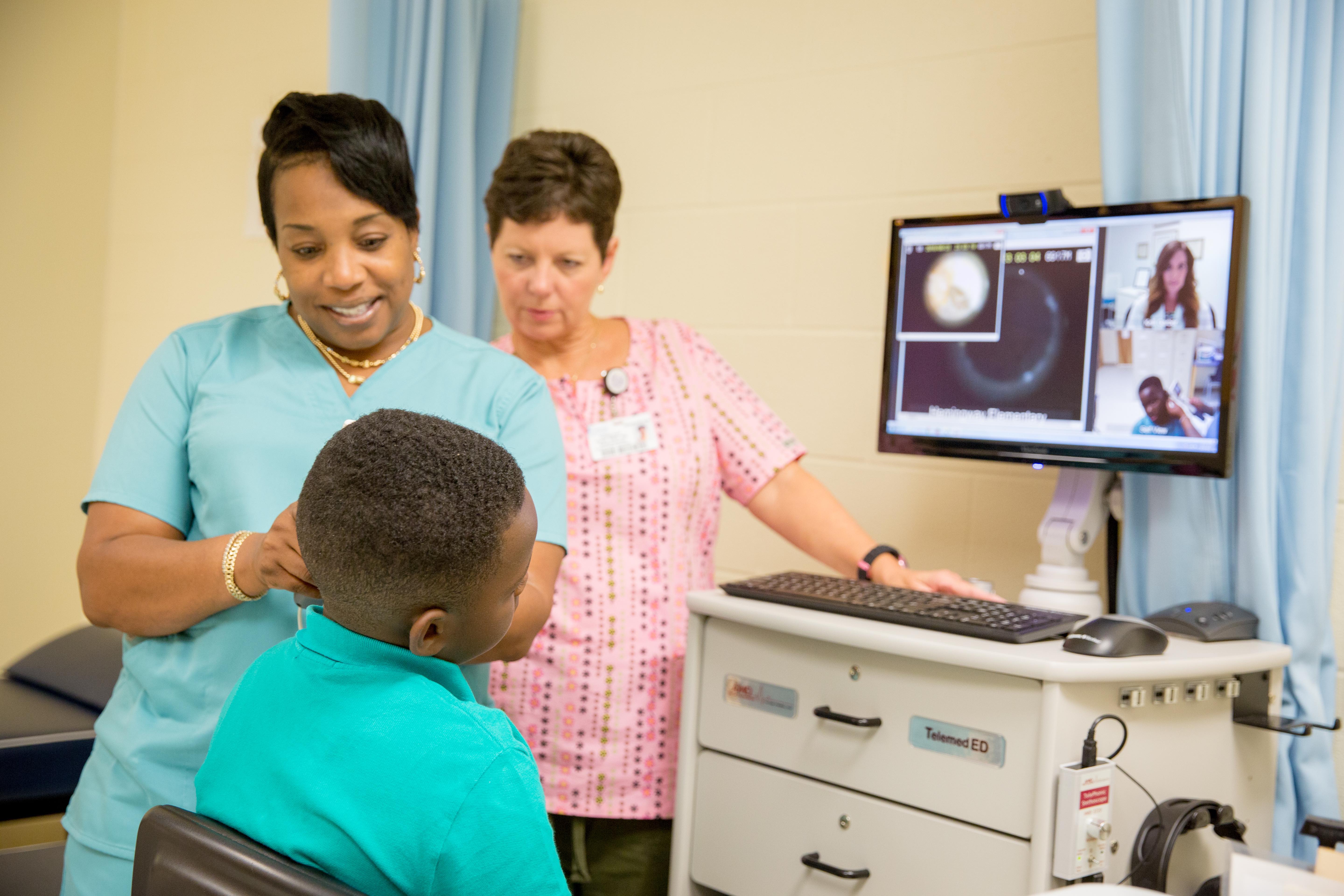 Kelli Garber, MSN, APRN, lead nurse practitioner & clinical integration specialist at the Medical University of South Carolina Center for Telehealth, consulting with a school nurse, telepresenter and student via a telehealth cart.