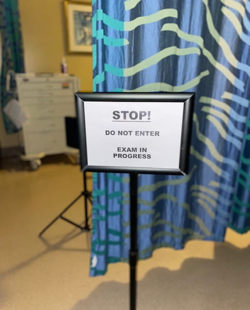 Detail photo of sign saying an examination is in progress