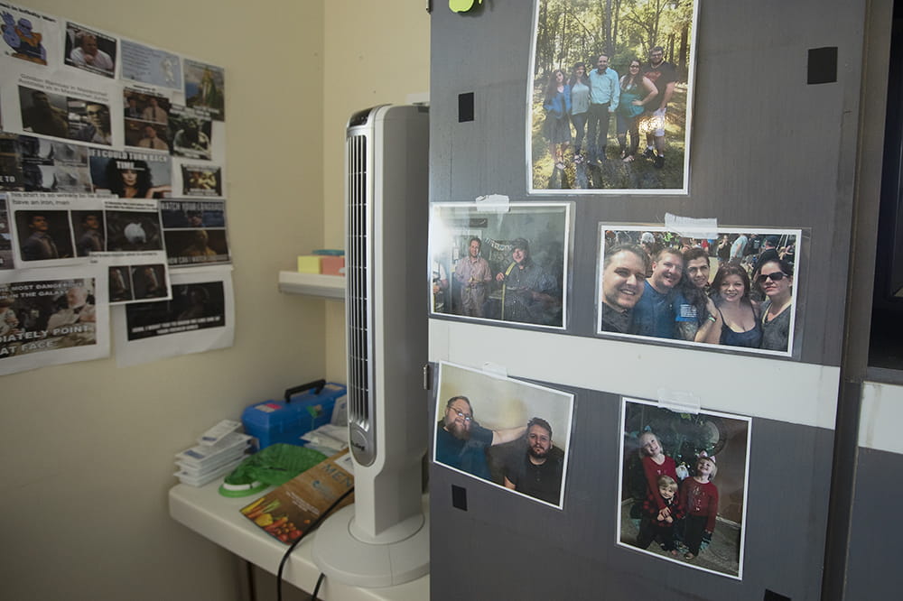 the cabinets and wall in a hospital room are covered with family photos and Internet memes