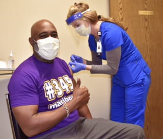 Dr. Gregory McCord being vaccinated.