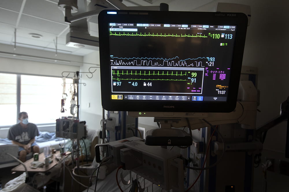 a father sits in a darkened hospital room