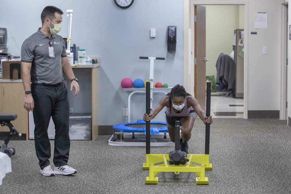 MUSC Physical Therapist Nathan Harris watches Vanessa Fry’s form during a physical therapy training session.