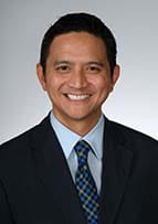 Head and shoulders shot of Dr. Alec DeCastro. He is clean shaven with dark hair, a coat and tie.