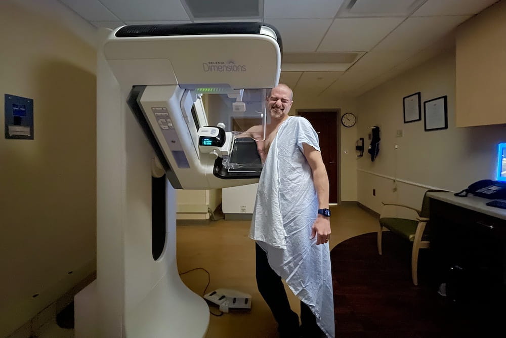 A man winces as he gets a mammogram