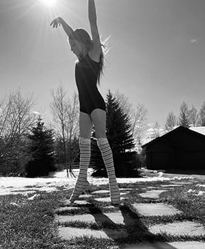 black and white image of young girl dancing outdoors