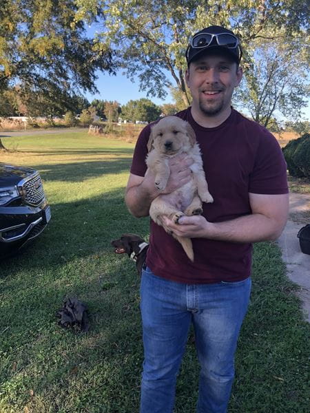 A man holds a fluffy puppy