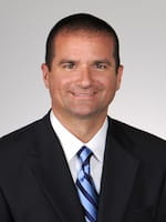headshot of dr. spiotta, wearing a suit jacket and blue tie