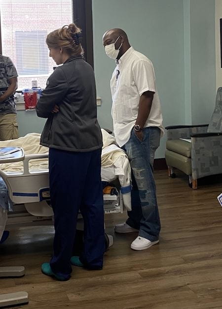 Dr. Hink and Keith Smalls check on a patient in the hospital