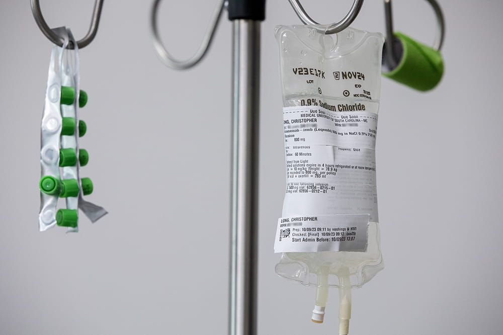 Metal stand with a clear IV bag hanging from it.