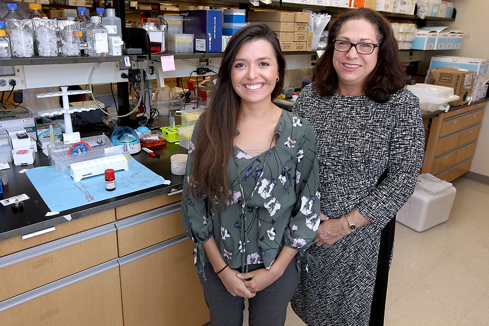 two women pose in a lab