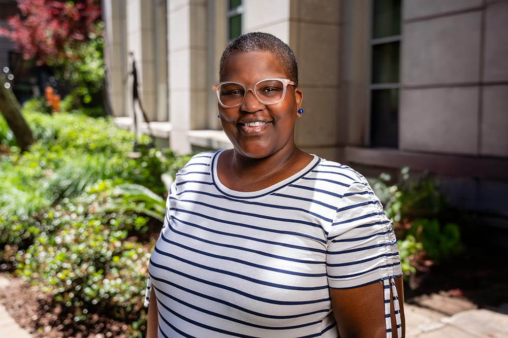 Uterine cancer patient Lakisha Pack smiles at the camera in a garden setting