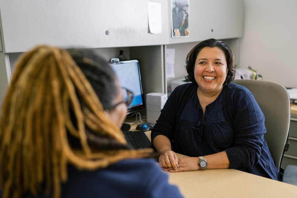 Family medicine physician Dr. Vanessa Diaz speaking with a care team member.