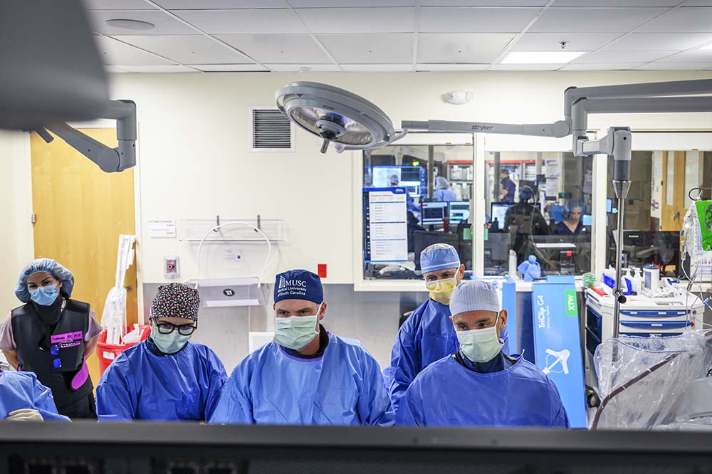 Five people in blue surgical scrubs