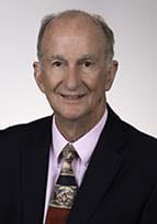 Headshot of a man wearing a suit and tie.