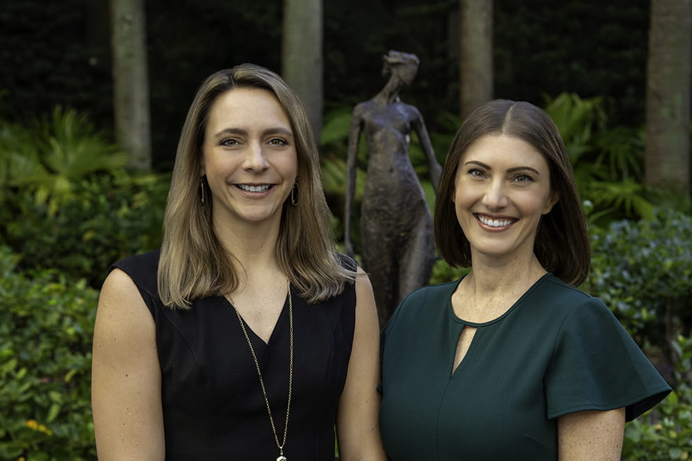two researchers pose in a garden setting 