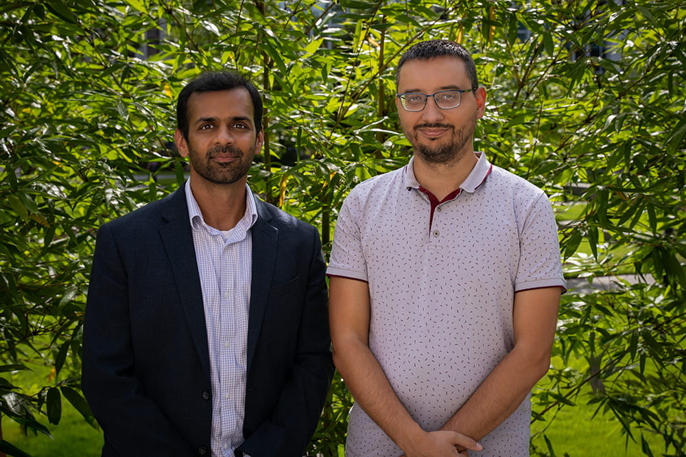 two cancer researchers pose in the garden
